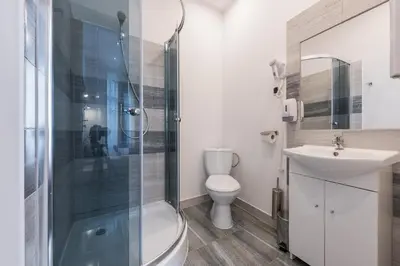 a bathroom with a shower and a toilet and a sink at 70s Hostel in Kraków
