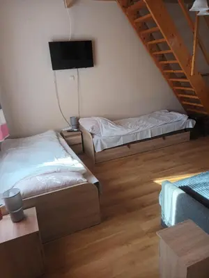 a room with two beds and a tv on the wall at U Adama in Wieliczka