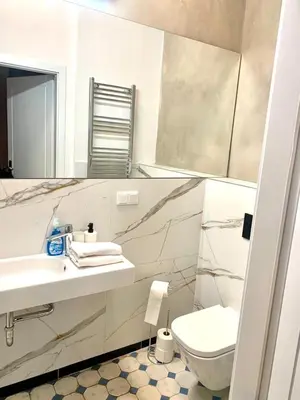 a bathroom with a sink and a toilet and a mirror at Florianska Deluxe Apartments with Air Condition in Kraków
