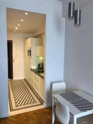 a kitchen and dining room with a table and chairs at Florianska Deluxe Apartments with Air Condition in Kraków
