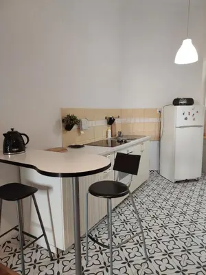 a kitchen with a table and two chairs and a refrigerator at Apartment Mariacki Tower in Kraków