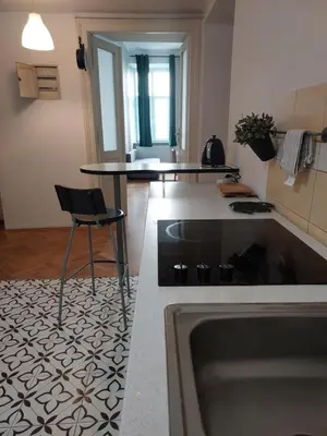 a kitchen with a counter and a table and a chair at Apartment Mariacki Tower in Kraków
