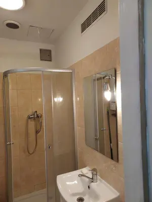 a bathroom with a shower and a sink and a mirror at Apartment Mariacki Tower in Kraków