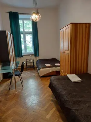 a room with a bed and a table and a window at Apartment Mariacki Tower in Kraków