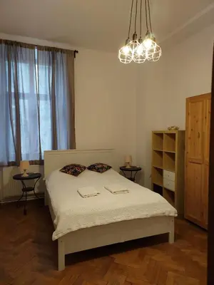 a bedroom with a bed and a chandelier at Apartment Mariacki Tower in Kraków