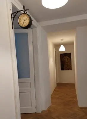 a clock hanging over a door in a hallway at Apartment Mariacki Tower in Kraków