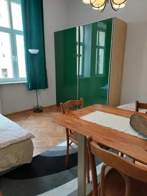 a room with a table and a green wall at Apartment Mariacki Tower in Kraków