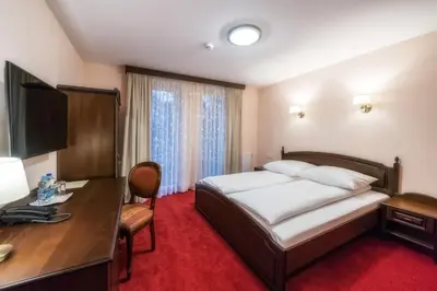 a hotel room with a bed and a desk at Dworek Skawiński in Skawina