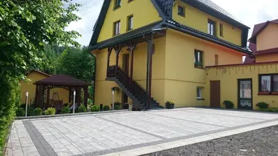 a yellow and black house with a black gate at Czesławka in Zawoja