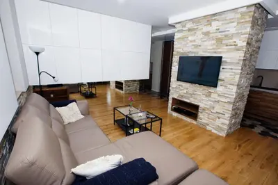 a living room with a couch and a stone fireplace at Apartament 
