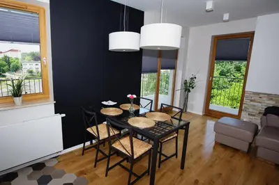 a black dining room with a table and chairs at Apartament 