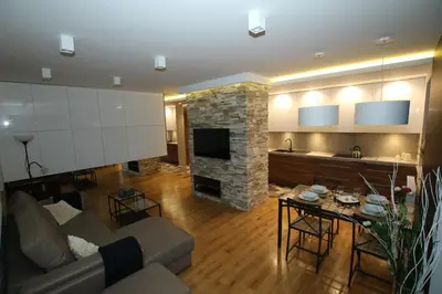a living room with a couch and a stone fireplace at Apartament 
