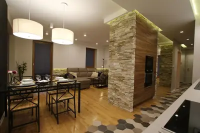 a living room with a table and a stone wall at Apartament 