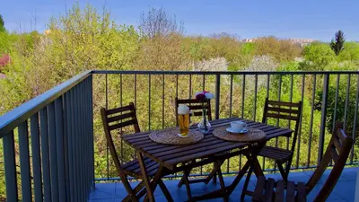 a wooden table with two chairs on a balcony at Apartament 