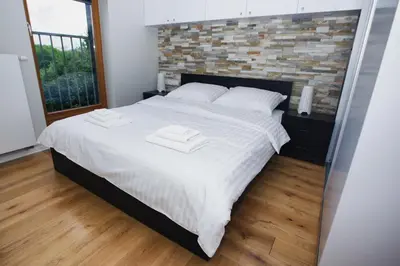 a bedroom with a large white bed with a brick wall at Apartament 