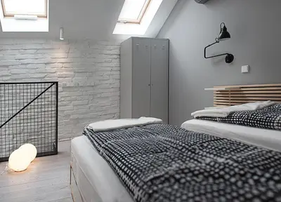 a bedroom with two beds and a brick wall at Modern Apartment46 / Kazimierz in Kraków