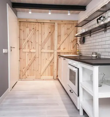 a kitchen with a wooden barn door at Modern Apartment46 / Kazimierz in Kraków