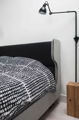 a bed with a black and white blanket and a lamp at Modern Apartment46 / Kazimierz in Kraków