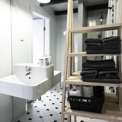 a bathroom with a white sink and a shelf with towels at Modern Apartment46 / Kazimierz in Kraków
