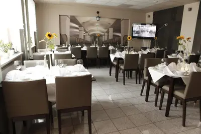 a dining room with tables and chairs and a tv at Standard Delegacyjny Bed & Breakfast in Dąbrowa Górnicza