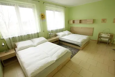 a bedroom with two beds and a table and windows at Standard Delegacyjny Bed & Breakfast in Dąbrowa Górnicza