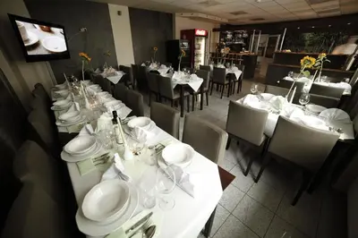 a dining room with tables and chairs with white plates at Standard Delegacyjny Bed & Breakfast in Dąbrowa Górnicza
