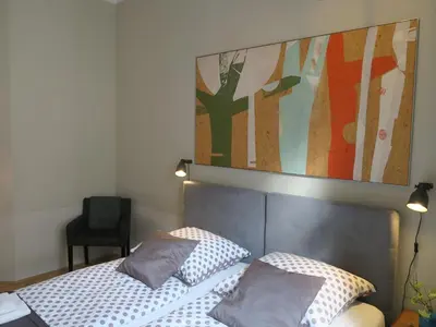 a bedroom with a bed and a painting on the wall at Pokoje Gościnne Poselska 20 in Kraków