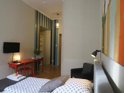 a bedroom with a bed and a desk with a computer at Pokoje Gościnne Poselska 20 in Kraków