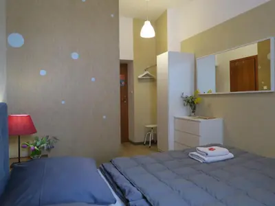 a bedroom with a blue bed and a mirror at Pokoje Gościnne Poselska 20 in Kraków