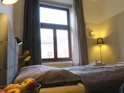 a bedroom with a window and a bowl of fruit on a bed at Pokoje Gościnne Poselska 20 in Kraków