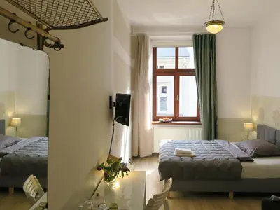 a bedroom with two beds and a window at Pokoje Gościnne Poselska 20 in Kraków