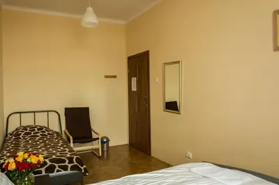 a bedroom with a bed and a mirror and a chair at Bubble Hostel in Kraków