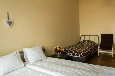 a bedroom with two beds and a bed with flowers on a table at Bubble Hostel in Kraków