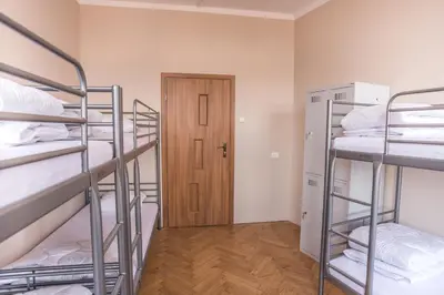 a room with three bunk beds and a door at Bubble Hostel in Kraków