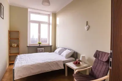 a small bedroom with a bed and a chair at Bubble Hostel in Kraków