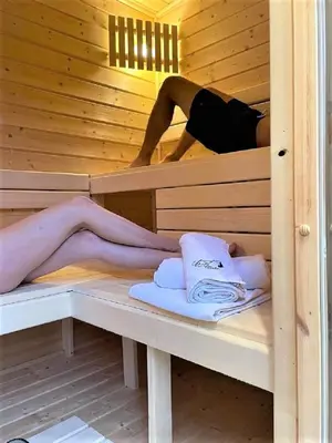 a woman laying in a sauna with her legs sticking out at Chata 