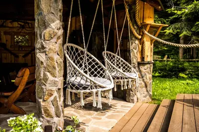 two wicker chairs sitting on the porch of a cabin at Chata 