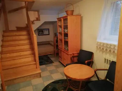 a room with a staircase and a table and chairs at Pokoje Gościnne Lalaj in Bolęcin