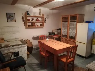 a kitchen with a wooden table and a refrigerator at Pokoje Gościnne Lalaj in Bolęcin