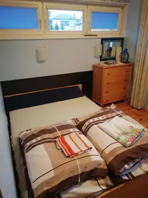 a bedroom with two beds and a dresser and a window at Pokoje Gościnne Lalaj in Bolęcin