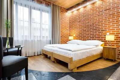 a brick walled bedroom with a bed and a desk at Krowoderska Apartments in Kraków