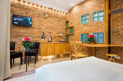 a hotel room with a brick wall and a bar at Krowoderska Apartments in Kraków