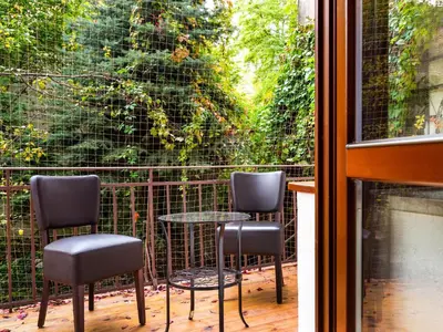 a patio with three chairs and a table and a window at Krowoderska Apartments in Kraków