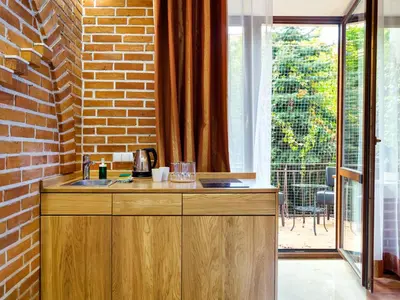 a kitchen with a sink and a brick wall at Krowoderska Apartments in Kraków