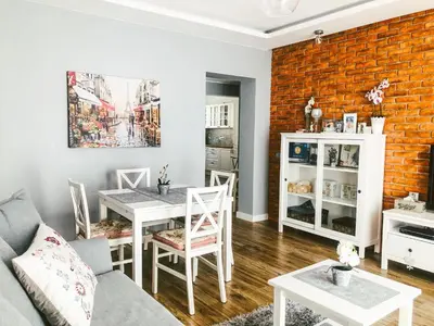 a living room with a couch and a table with chairs at Apartament LUSCINIA z 2 sypialniami in Kraków