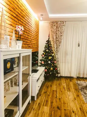 a living room with a christmas tree in the corner at Apartament LUSCINIA z 2 sypialniami in Kraków