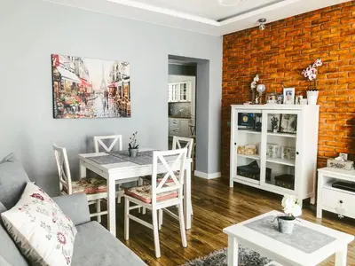 a living room with a table and chairs and a brick wall at Apartament LUSCINIA z 2 sypialniami in Kraków
