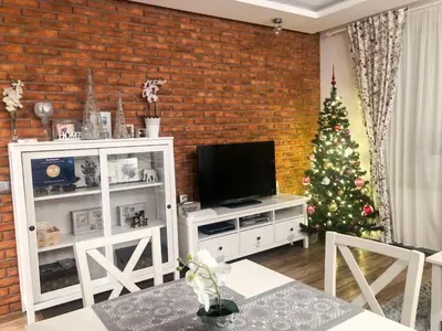 a living room with a christmas tree and a television at Apartament LUSCINIA z 2 sypialniami in Kraków