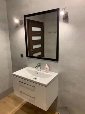 a bathroom with a white sink and a mirror at Arkada Wadowice in Wadowice