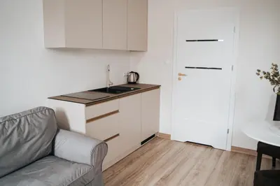 a living room with a couch and a kitchen at Arkada Wadowice in Wadowice